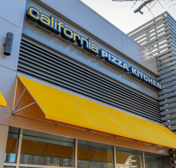 angled architectural louvers providing accent above yellow awning at california pizza kitchen