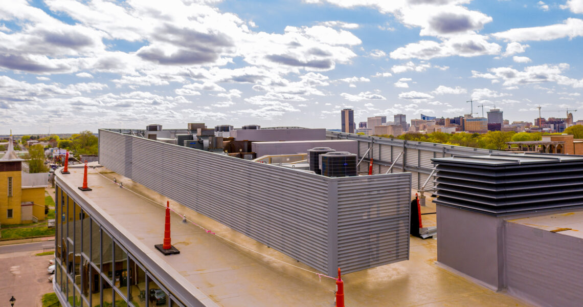 Perforated corrugated RoofScreen concealing HVAC equipment on commercial kitchen rooftop